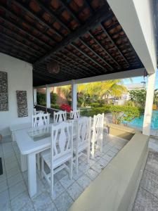 プライア・ドス・カルネイロスにあるBela Casa Praia dos Carneiros Condominio Beira Mar Seg 24hrs FRENTE PISCINAS NATURAIS!!!のパティオの白いテーブルと椅子