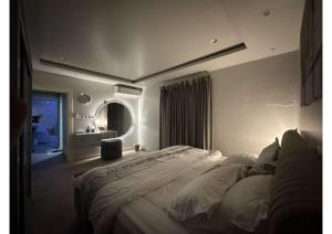 ein Schlafzimmer mit einem großen Bett und einem Spiegel in der Unterkunft شقة تتكون من صالة وغرفة ومطبخ, حي النرجس in Riad