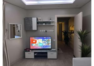 ein Wohnzimmer mit einem TV in der Unterkunft شقة تتكون من صالة وغرفة ومطبخ, حي النرجس in Riad