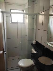 y baño con aseo, lavabo y espejo. en Flat no Turu en São Luís