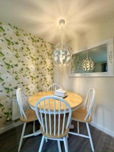 a dining room with a wooden table and chairs at 4 Bed Town House with free parking in Eaton Socon