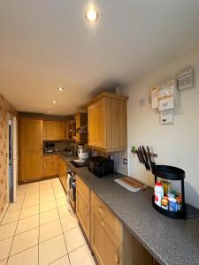 uma cozinha com armários de madeira e uma bancada em 4 Bed Town House with free parking em Eaton Socon