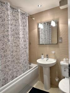 a bathroom with a sink and a shower curtain at 4 Bed Town House with free parking in Eaton Socon