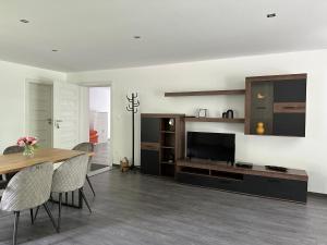 a living room with a dining table and a television at Riverside Residence in Trstice