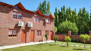 un edificio de ladrillo con 2 ventanas y 2 aparatos de aire acondicionado en Hospedaje, Departamentos J&R en Perito Moreno