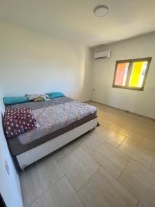 um quarto com uma cama e piso em azulejo em Villa Amarelo em Beberibe