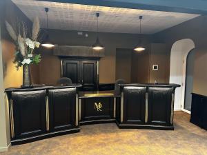 a salon with black cabinets and a vase of flowers at LE MANOIR DU ROSELIER HOTEL 3 étoiles in Plérin