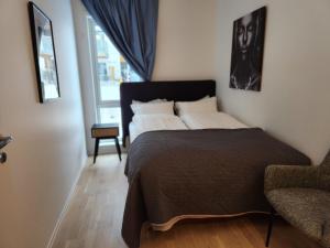 1 dormitorio con 1 cama, 1 silla y 1 ventana en Gjerdrum/ Oslo apartment for your trip/holiday en Gjerdrum