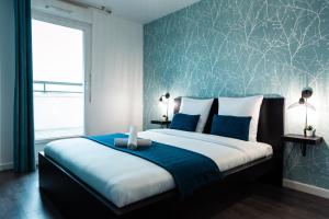 a bedroom with a large bed with a blue wall at Suite Familiale, Disneyland Paris, 8 personnes in Montévrain