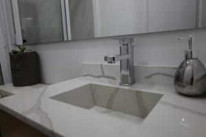 La salle de bains est pourvue d'un lavabo blanc et d'un miroir. dans l'établissement Hotel Mado, à Jalostotitlán