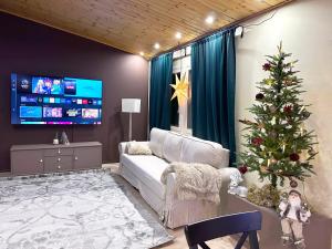 a living room with a christmas tree and a white couch at Linnunvilla with sauna in Rovaniemi