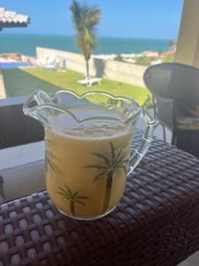 a cup of coffee on a table with a view of the beach at Villa Amarelo in Beberibe