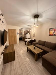 uma sala de estar com um sofá e uma mesa em Petkovi Аpartments, Borovets Gardens - One-bedroom and Two-bedroom apartments em Borovets