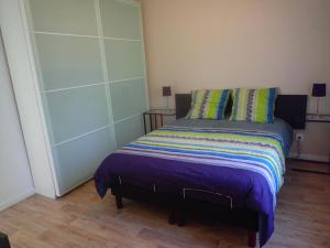 a bedroom with a bed with a purple comforter at Le SUN DECK in Dammarie-lès-Lys