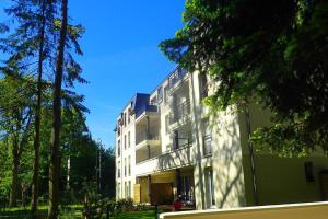 a large white building with trees in front of it at Le SUN DECK in Dammarie-lès-Lys