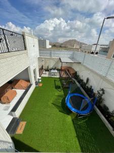 un balcón con un patio de césped verde en شاليهات وجدان الهدا, en Al Hada