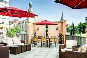 un patio al aire libre con mesas, sillas y sombrillas en Residence Inn Washington, DC/ Downtown en Washington