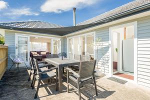 eine Terrasse mit einem Tisch und Stühlen auf einem Haus in der Unterkunft Lavaud Delight - Akaroa Holiday Home in Akaroa