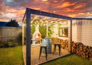 een achtertuin met een grill en een vuurplaats bij Lavaud Delight - Akaroa Holiday Home in Akaroa