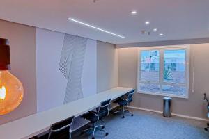 an office with a desk and chairs and a window at Blend Smart Marista 2 Quartos in Goiânia