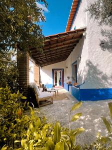 a patio of a house with a chair and a table at Casa da Loba in Casas Novas de Marés