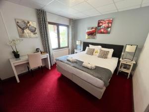 una camera con un grande letto e un tappeto rosso di Le Divona a Divonne-les-Bains