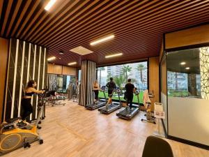 a gym with people exercising on tread machines in a room at Serenity SPA ALL-IN apartment Luxury resort private beach in Alanya