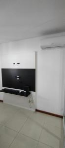 a white room with a wall with a tv on it at Vista incrível na melhor localização da praia da costa in Vila Velha