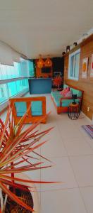 - un salon avec plusieurs tables et un canapé dans l'établissement Vista incrível na melhor localização da praia da costa, à Vila Velha