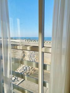 una ventana con vistas a la playa en Al seeb beach appartements, en Seeb