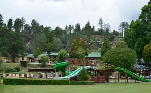 a playground with a slide in a park at Fairways resort 6 sleeper unit in Drakensberg Garden