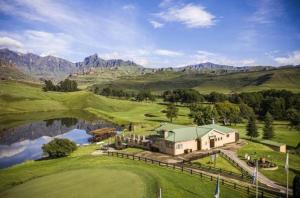 an aerial view of a house with a lake and mountains at Fairways resort 6 sleeper unit in Drakensberg Garden