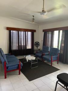 a living room with blue chairs and a table at Ziara Apartments in Nadi