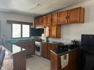 a kitchen with wooden cabinets and a stove top oven at Ziara Apartments in Nadi
