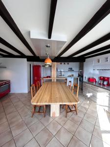 a large kitchen with a wooden table and chairs at Lerefugedetiti in Buissard