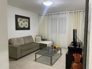 a living room with a couch and a coffee table at Apartamento grande 900m do centro in Diamantina