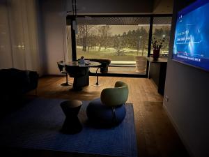 a living room with a television and a table and chairs at Mezapark Design Apartments in Rīga