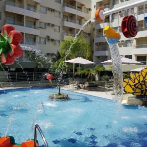 una piscina con una fuente en un hotel en Rio Quente-GO SERRA PARK com 2 camas de casal en Rio Quente