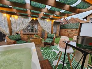 a room with a bath tub and a table and chairs at Villa La'Vie in eMalahleni
