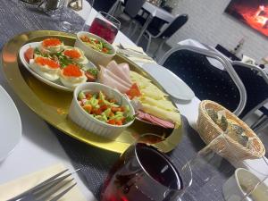 una bandeja con un plato de comida en una mesa en Rezydencja Myśliwska - Apartamenty en Koszalin