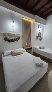 two beds in a bedroom with white walls at HOTEL BOHO BOUTIQUE in Quibdó