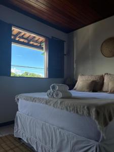 a bedroom with a large bed with a window at La Bahianita in Itacaré