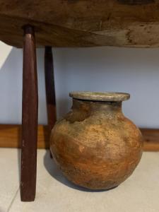 a brown vase sitting under a wooden table at La Bahianita in Itacaré