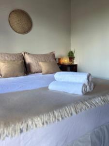 a large white bed with a white towel on it at La Bahianita in Itacaré