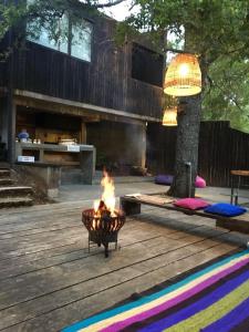 eine Feuerstelle auf einer Holzterrasse mit einem Baum in der Unterkunft Casa Calafquen in Panguipulli