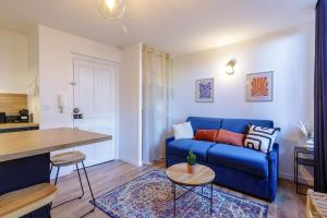 sala de estar con sofá azul y mesa en La Maison 44 - T2 - central, terrasse, garage, en Montélimar