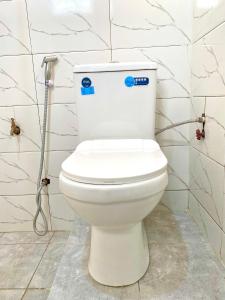 um WC branco numa casa de banho com azulejos brancos em Drew Apartment Tanga em Tanga