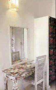 a dressing table with a mirror and a chair at Lalasalama B&B in Watamu