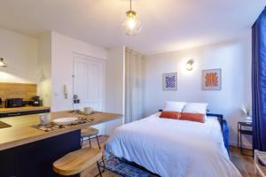 1 dormitorio con cama, escritorio y cocina en La Maison 44 - T2 - central, terrasse, garage, en Montélimar