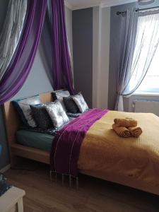 um quarto com uma cama com cortinas roxas em Silwer ROOM em Cracóvia